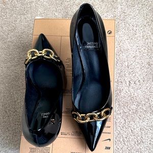 Jeffrey Campbell Black patent leather pointed toe heel with gold buckle design.